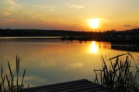 view from the wooden pier to the lake at dusk