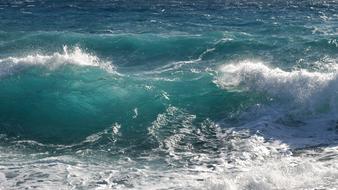 Close-up of the beautiful, shiny, turquoise and white waves in sunlight