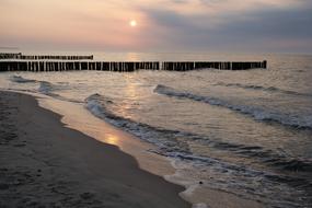 sandy beach with breakwaters at dusk