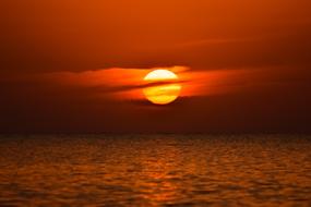 bright setting sun in the clouds over the sea