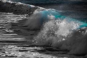 Close-up of the beautiful, white and turquoise waves in the ocean, in light