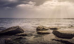 gray cloudy sky over stones on the sea coast