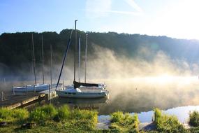 sailboats on a lake in germany in the morning fog