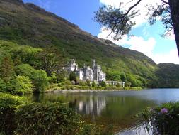 Beautiful landscape with the castle near the colorful hill with plants, on the coast