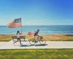 people with american flags on the beach