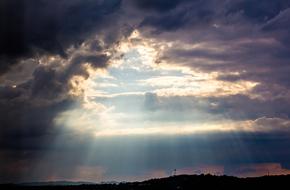 sunbeams behind dark clouds