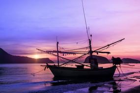 dark silhouette of fishing Boat at purple Sunset, thailand