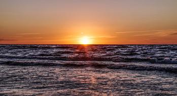 sunset in the dark ocean waves