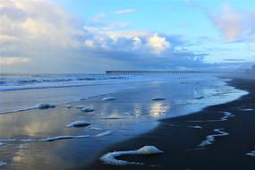 Beautiful and colorful beach of the ocean, at colorful and beautiful sunrise, among the clouds