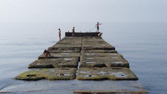 People on the beautiful stone pier among the sea