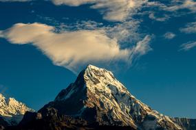 Beautiful landscape with the snowy Annapurna mountain in sunlight, in Nepal, under the blue sky with white clouds