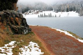 Beautiful landscape of the colorful shoe of the lake, with plants and snow, in the morning mist, in Davos, Switzerland