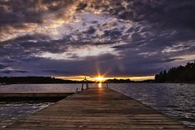 view from the wooden pier to the sunset in the clouds