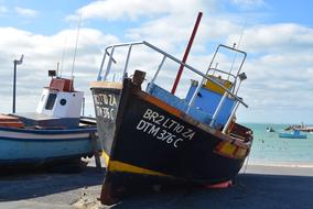 Colorful fishing boats on the beach of the sea, in sunlight