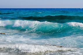 Close-up of the beautiful and colorful waves in the sea, in sunlight