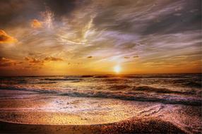 setting sun in the clouds over the sea coast of denmark