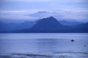 boat on the lake with mountains in the background