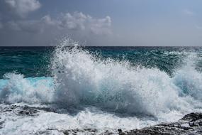 windy weather, high foamy Waves Splashing on rock