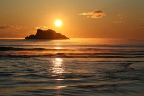 setting sun over a mountain in the sea