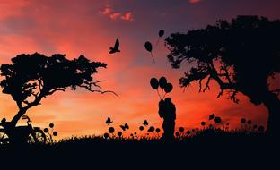 silhouette of couple with balloons in nature