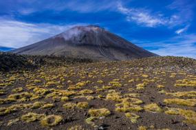 Beautiful and colorful landscape with Mount Doom in New Zealand, under the blue sky with white clouds
