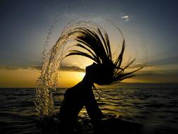 silhouette of a girl in the water at dusk