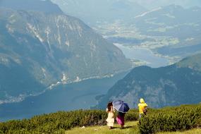 tourists walk near green bushes on a mountain in austria