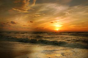 sunset in the clouds over the sea surf