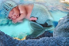 Cute, sleeping baby child in mermaid clothing, above the sea, clipart