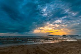 Beautiful landscape of the sandy beach of Krabi, Thailand, at beautiful, orange sunset, among the clouds