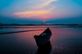 Beautiful landscape of the ocean beach with boat, at colorful and beautiful sunset with clouds