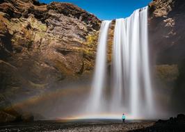 Rainbow On A High Rocky Waterfall