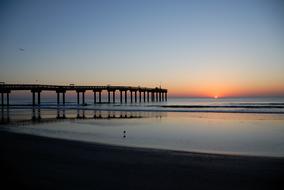 fishing pier over the sea during sunset