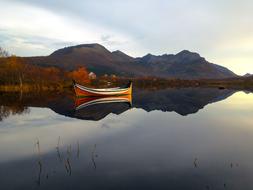 Beautiful landscape with colorful boat near the coast with colorful mountains in Northern Norway