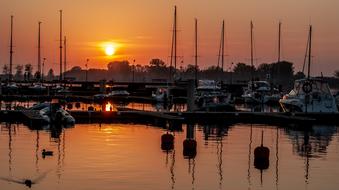 Boats in the port of the lake, at colorful and beautiful sunset with clouds, in the evening