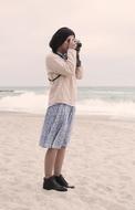 girl with a camera on the beach