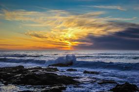 sea coast against the background of a yellow sunset in the clouds