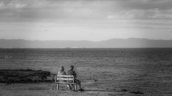 couple on bench overlooking the sea