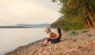 girl with dog on the beach near the river