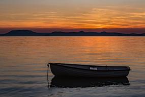 wooden boat on the lake during sunset