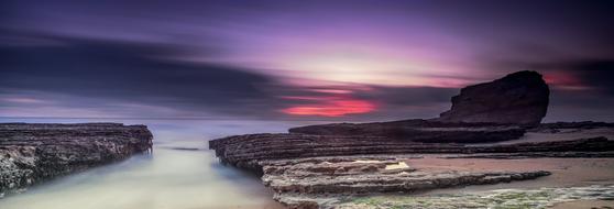 river among rocks against a purple sky