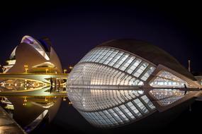 modern futuristic architecture reflected in water at night