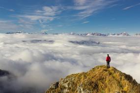 man at mountain summit over Sea ââOf ââClouds, alpine panorama