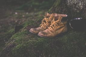 old leather boots on moss on stone