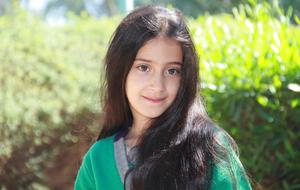 girl with long black hair in a green park