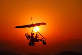 two persons on Aircraft Silhouette at red Sunset sky