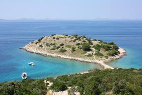 Beautiful landscape with the island with green plants, among the sea, in Croatia, under the blue sky