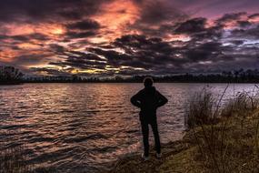 silhouette of a man on the lake against the background of sunset in Bavaria