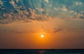 Beautiful waterscape of the ocean, at beautiful, orange sunset, among the clouds