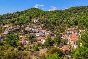 Beautiful and colorful Vavatsinia Village on the mountain with colorful plants in Cyprus, under the blue sky with clouds